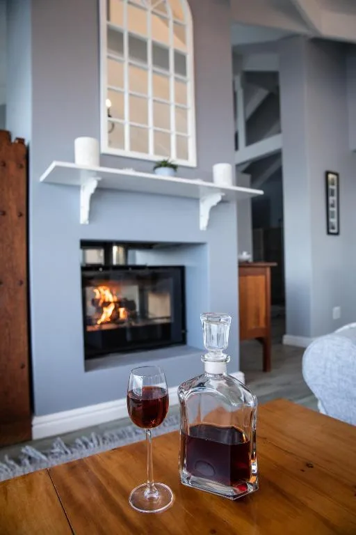 Modern lounge with fireplace, white shelving, and wooden table with drinks