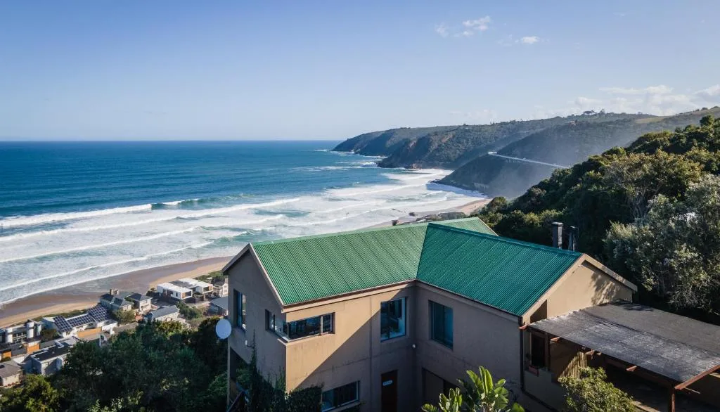 Dramatic coastal cliffs and sandy beach with turquoise ocean waters
