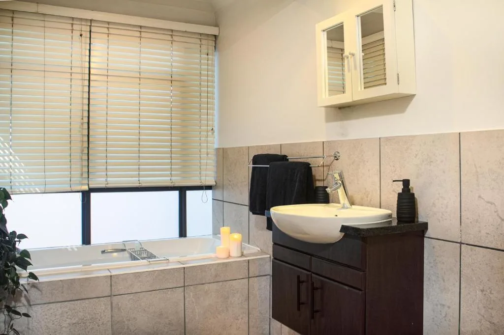 Modern bathroom with soaking tub, vessel sink, and natural light from window