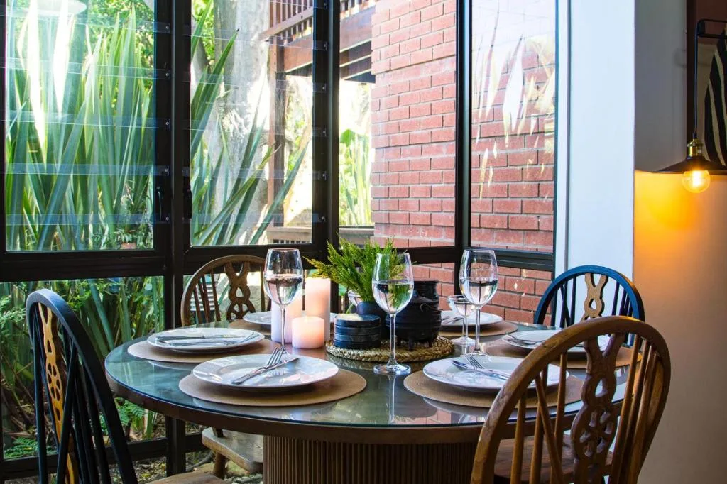 Elegant round dining table set for four with wine glasses and place settings