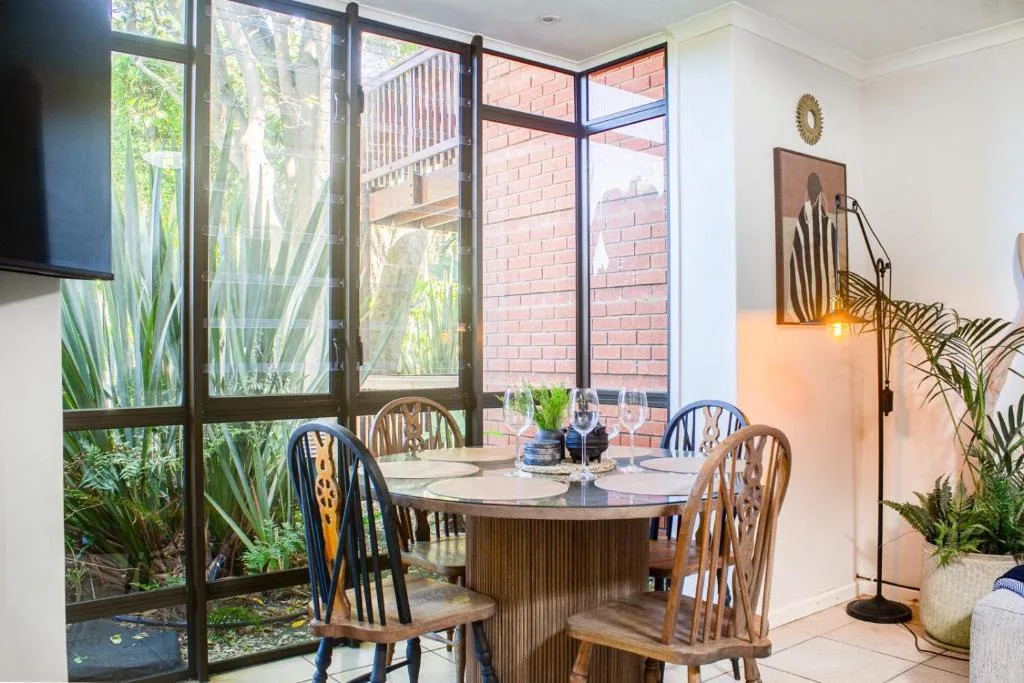 Elegant dining area with round table and garden views through large windows