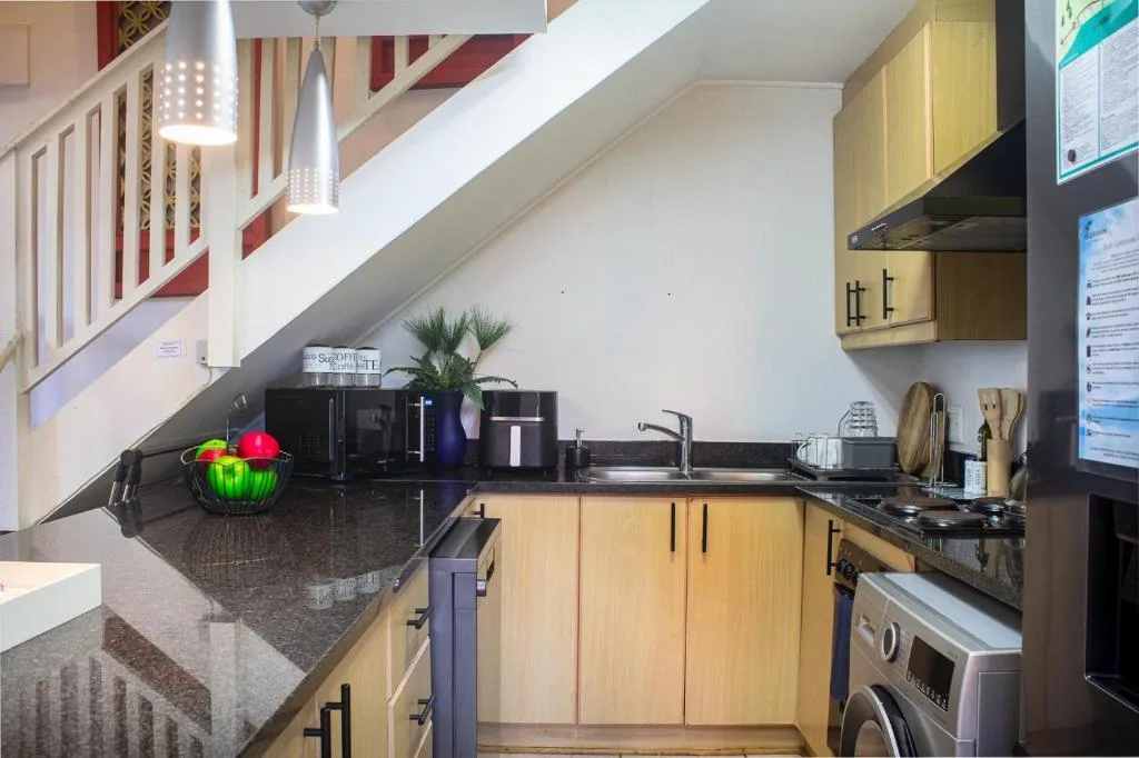 Modern kitchen with wooden cabinetry, dark countertop, and stainless steel appliances