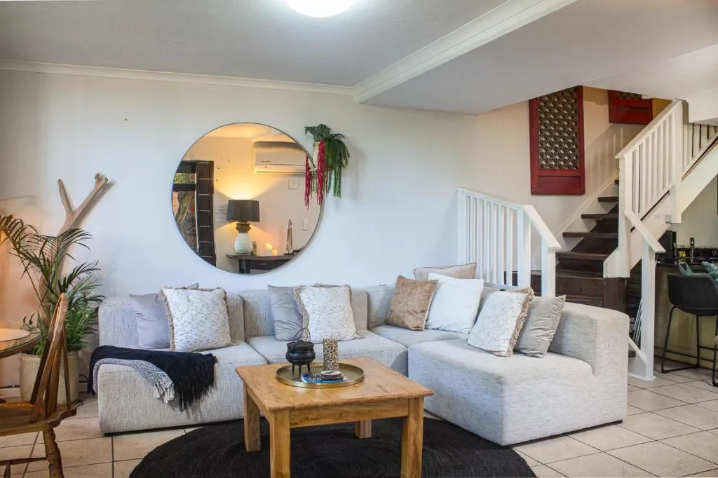 Spacious open-plan lounge with cream L-shaped sofa and wooden coffee table