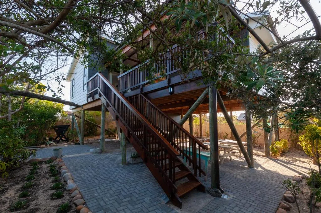 Modern house with wooden deck stairs and lush garden surroundings