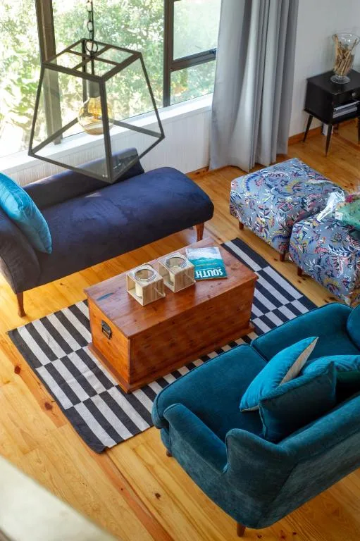 Modern lounge with blue velvet sofas, wooden coffee table, striped rug