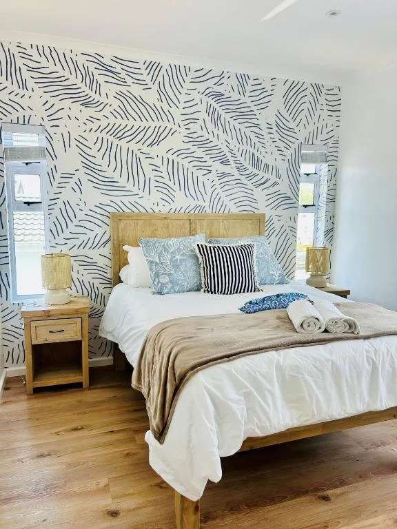 Modern bedroom with wooden bed frame and patterned accent wall