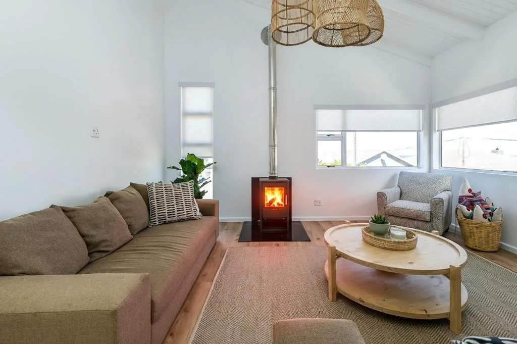Bright modern lounge with sofa, wood-burning stove, and comfortable seating