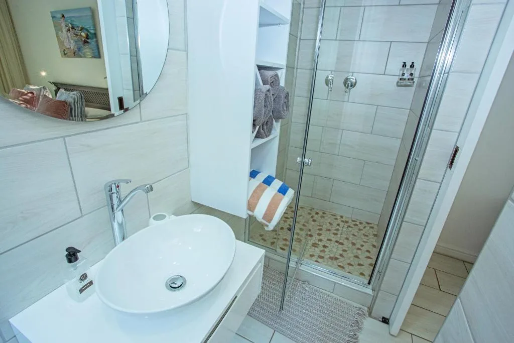 Modern bathroom with round sink vanity and glass-enclosed shower enclosure