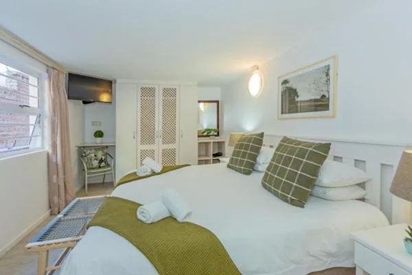 Bright bedroom with twin beds, green accents, and modern furnishings