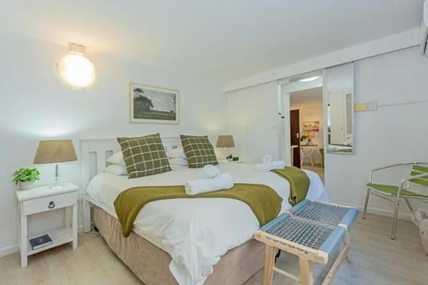 Bright bedroom with double bed, white bedding, and green accents throughout