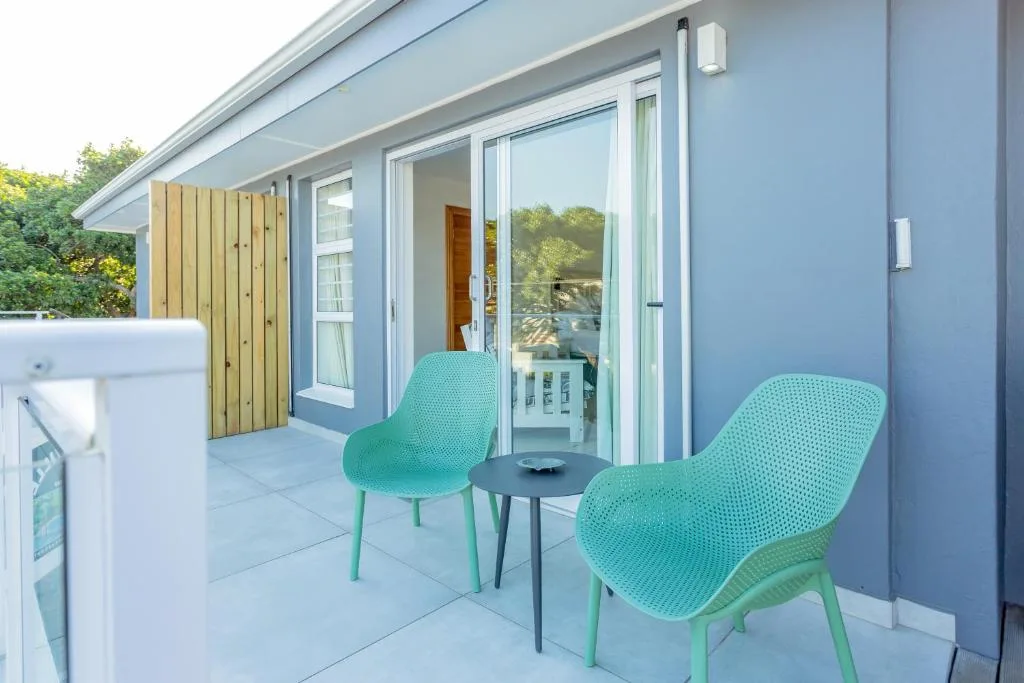 Modern patio with turquoise chairs and small table overlooking garden