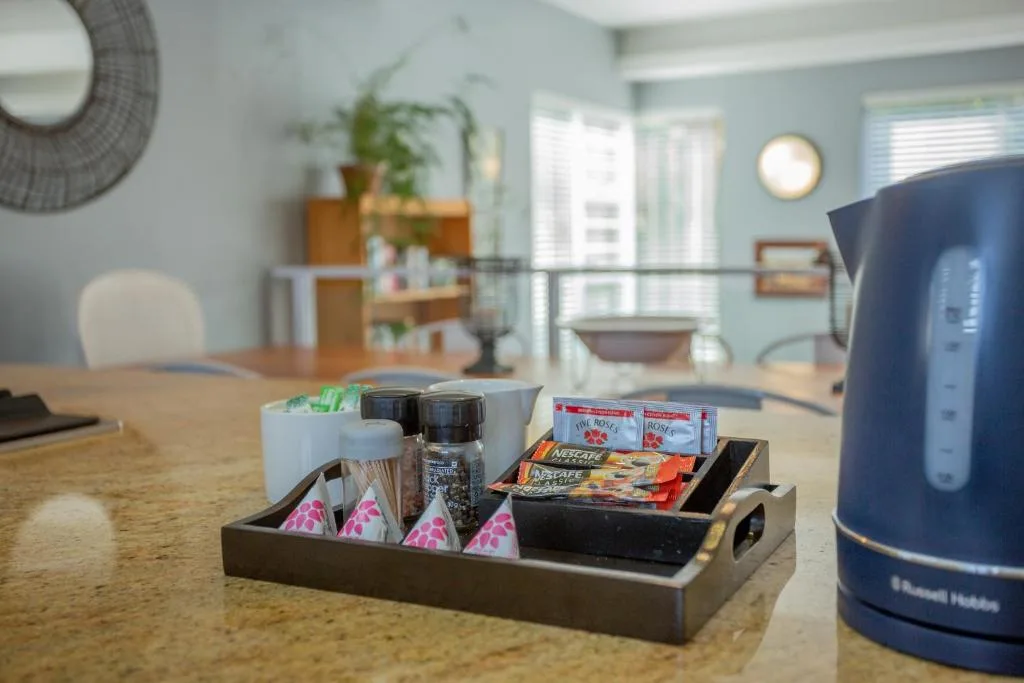 Welcome tray with tea, coffee, and snacks on kitchen counter