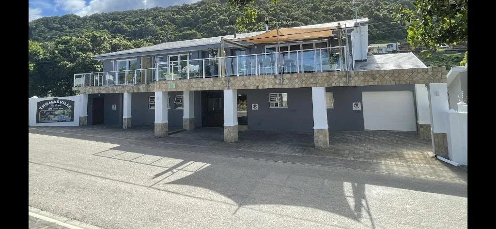 Modern two-story building with large windows and covered parking bays