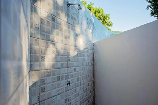 Modern white brick exterior wall with patterned architectural details and gate