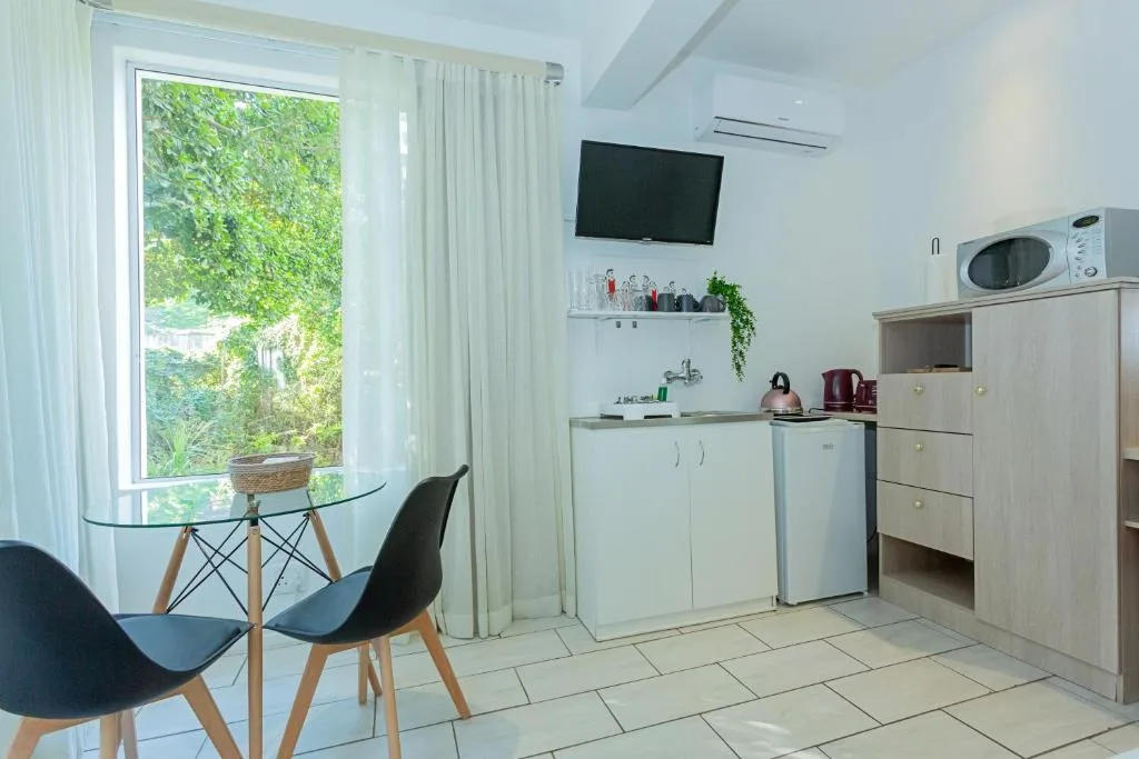 Modern kitchen with white cabinetry, stainless steel appliances, and garden view