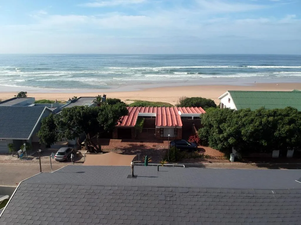 Beachfront property with ocean and sandy beach stretching to horizon