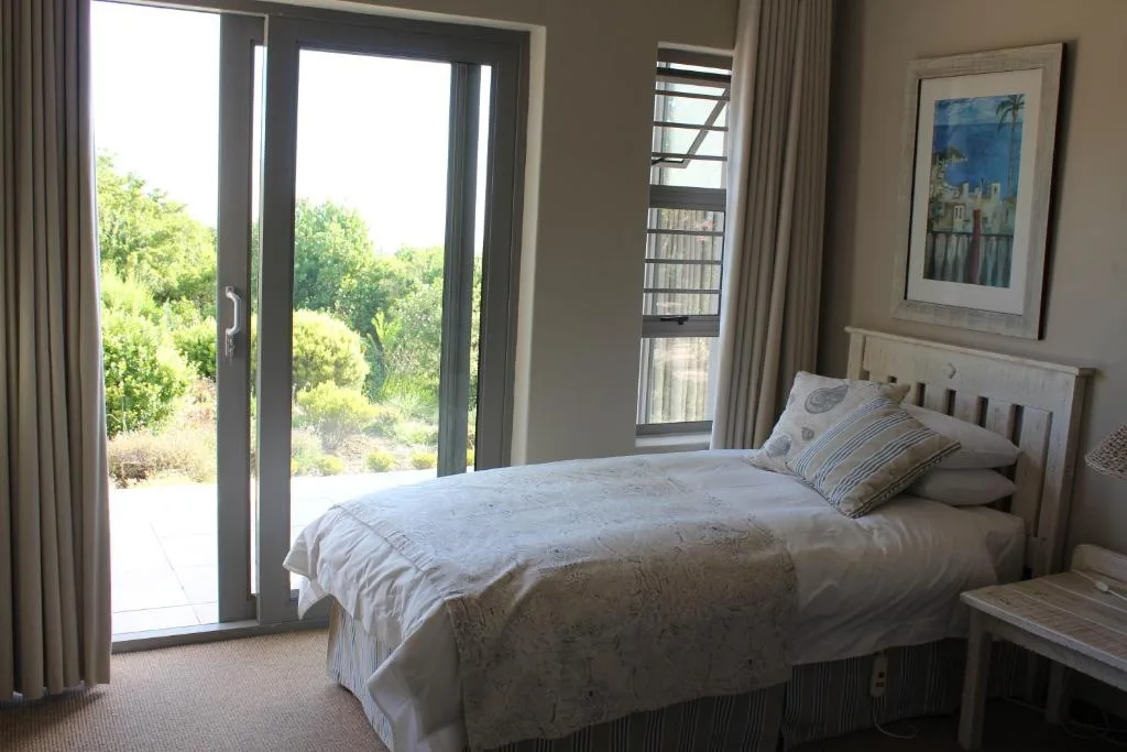 Bright bedroom with queen bed, garden views through sliding doors