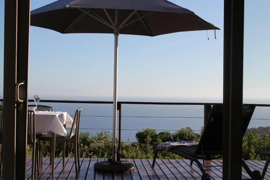 Shaded deck with umbrella overlooking serene lagoon water view