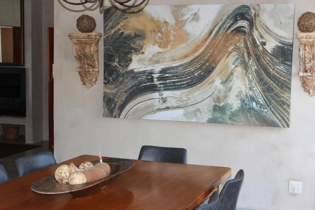 Wooden dining table with modern artwork and decorative wall elements above