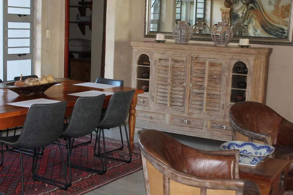 Elegant dining room with wooden table, leather chairs, and storage cabinet