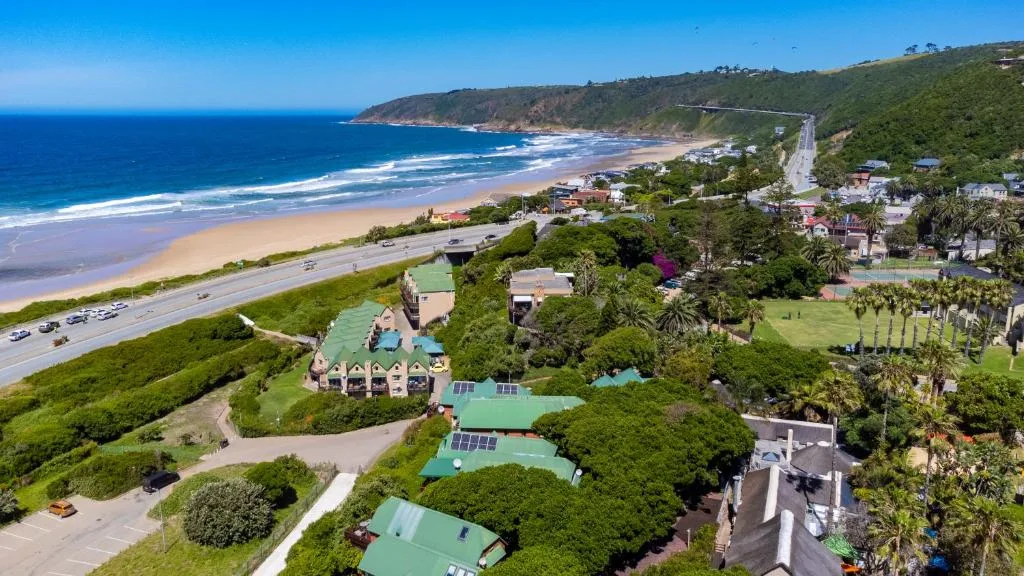 Aerial view of beachfront property with pristine sandy beach and blue ocean