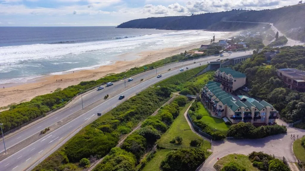 Aerial coastal view of beach, ocean, cliffs, and beachfront property complex