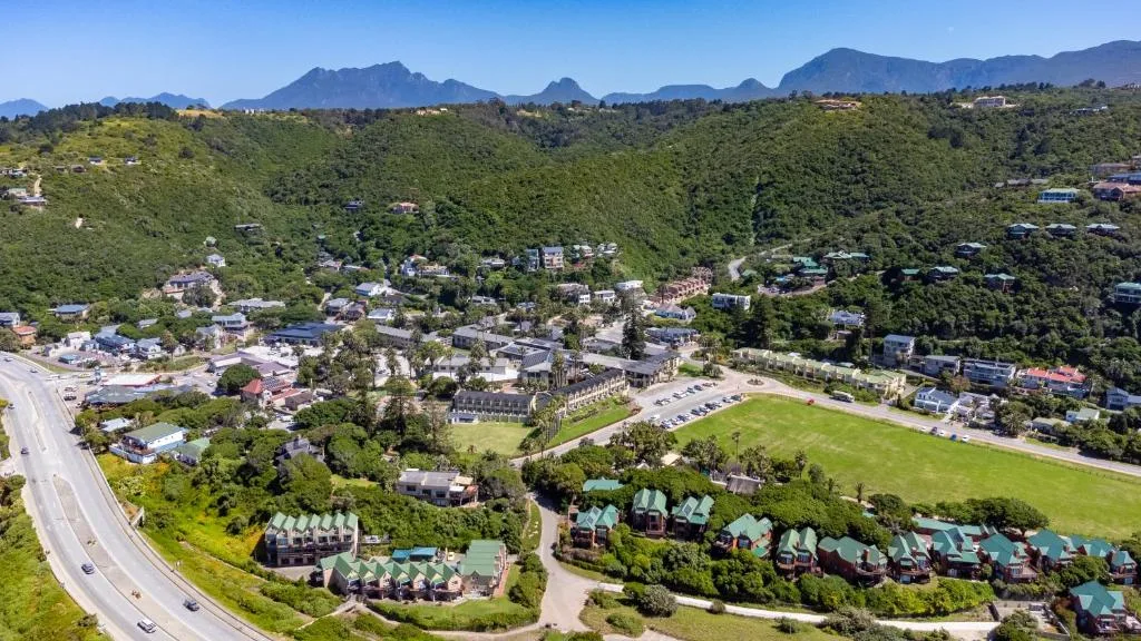 Aerial view of Wilderness town nestled between mountains and lush green hills