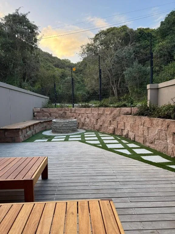 Spacious outdoor deck with fire pit, wooden benches, and garden seating