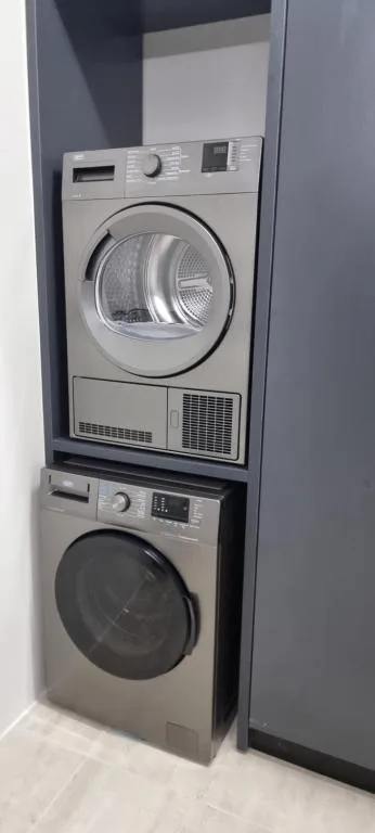 Stacked washer and dryer units in modern laundry closet space