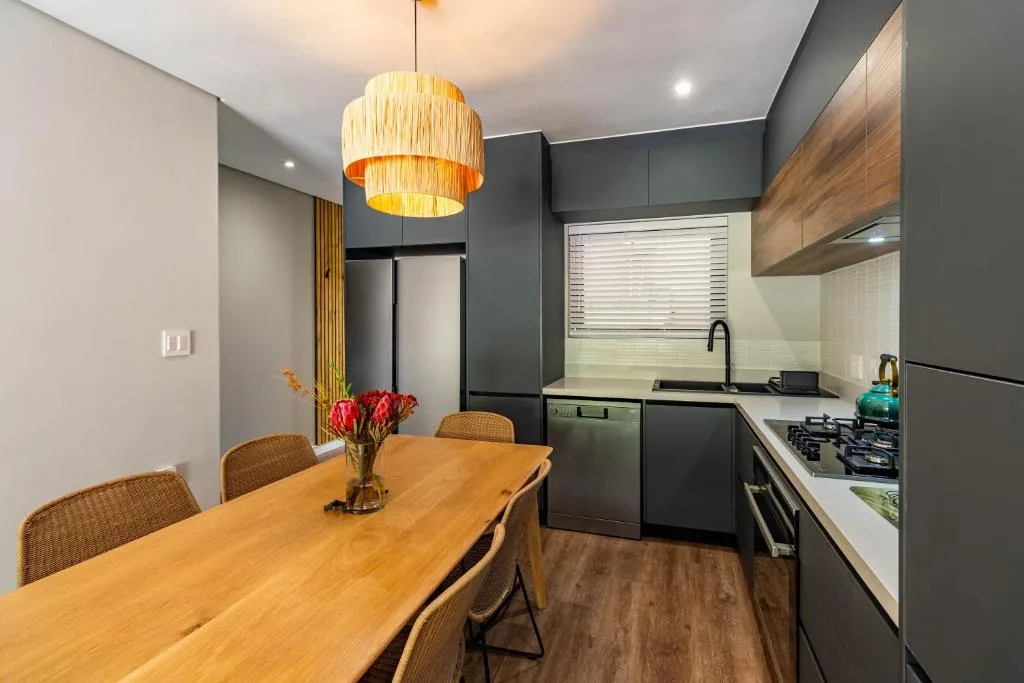 Modern dining table with rattan chairs and pendant light fixture