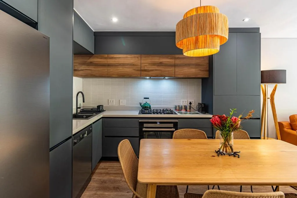 Modern kitchen with dark cabinetry, wooden accents, and pendant lighting fixture
