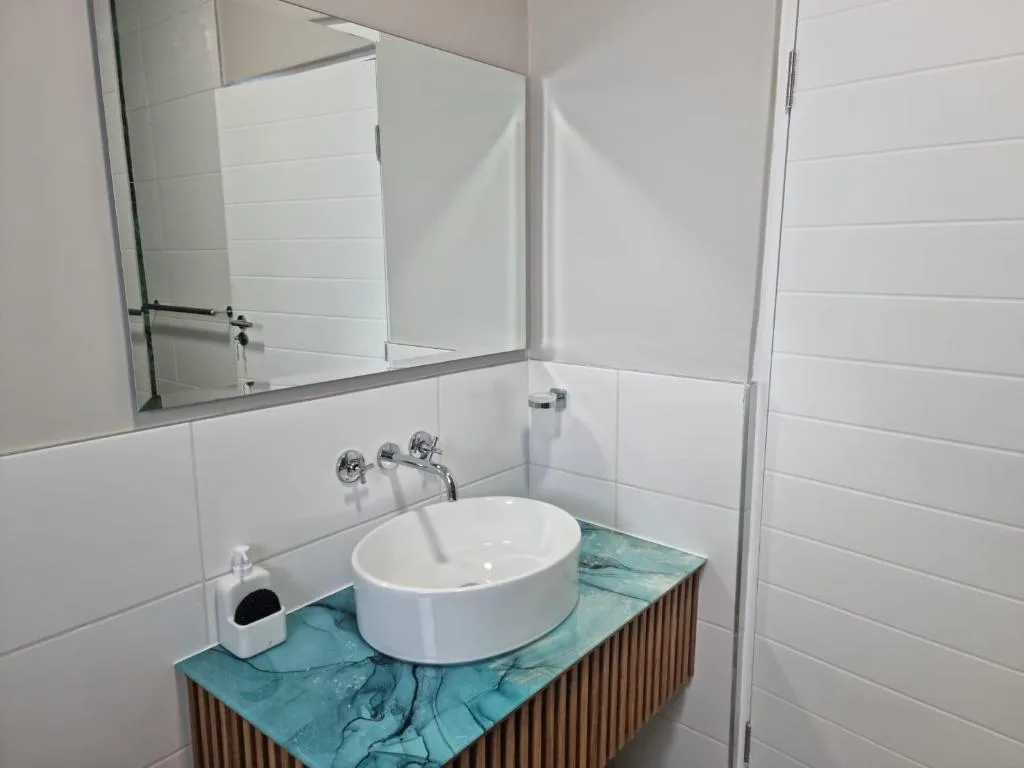 Modern bathroom with round white sink and turquoise marble vanity