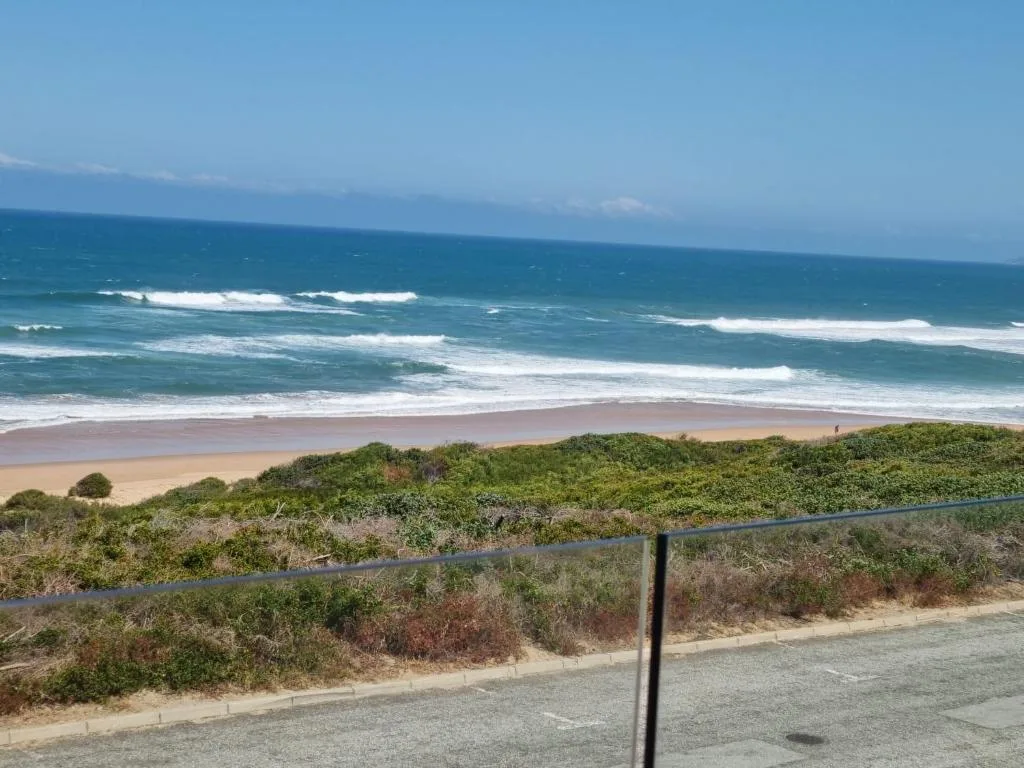 Ocean waves and sandy beach with coastal dunes from property vantage point