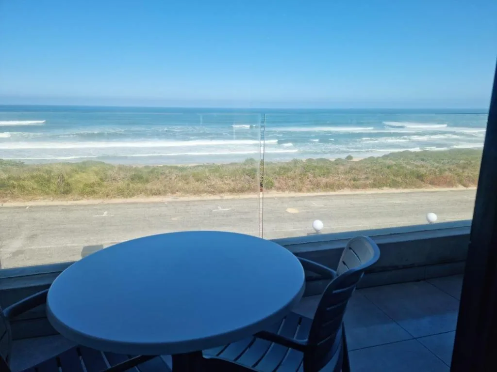 Ocean and beach vista from beachfront deck with dining table