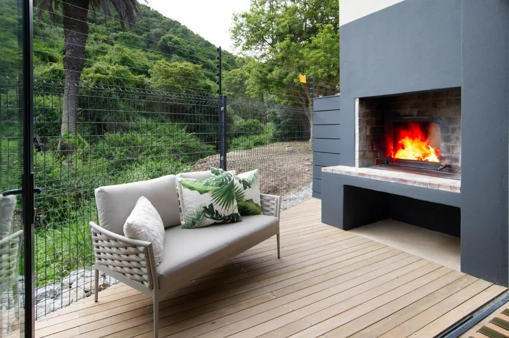 Outdoor deck with sofa, fireplace, and lush mountain views