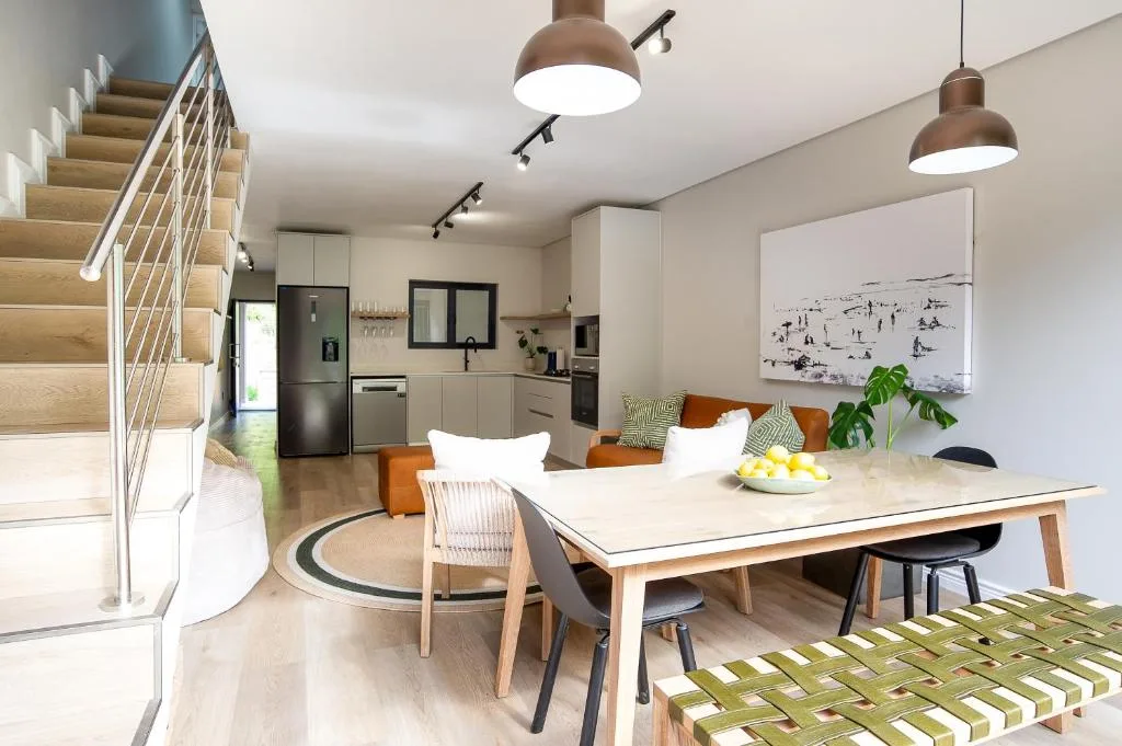 Modern dining table with chairs in open-plan kitchen and lounge area