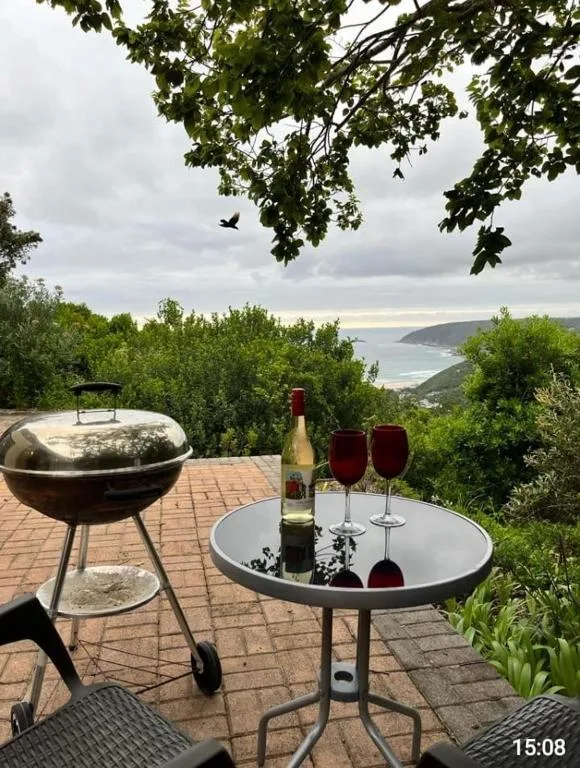 Outdoor braai and wine setup on brick patio overlooking coastal lagoon
