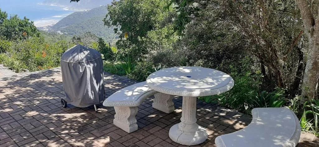 Stone tables on paved outdoor deck with mountain views and garden surroundings