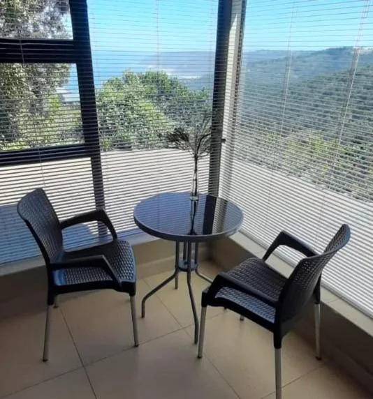 Outdoor seating area with table and chairs overlooking mountain landscape
