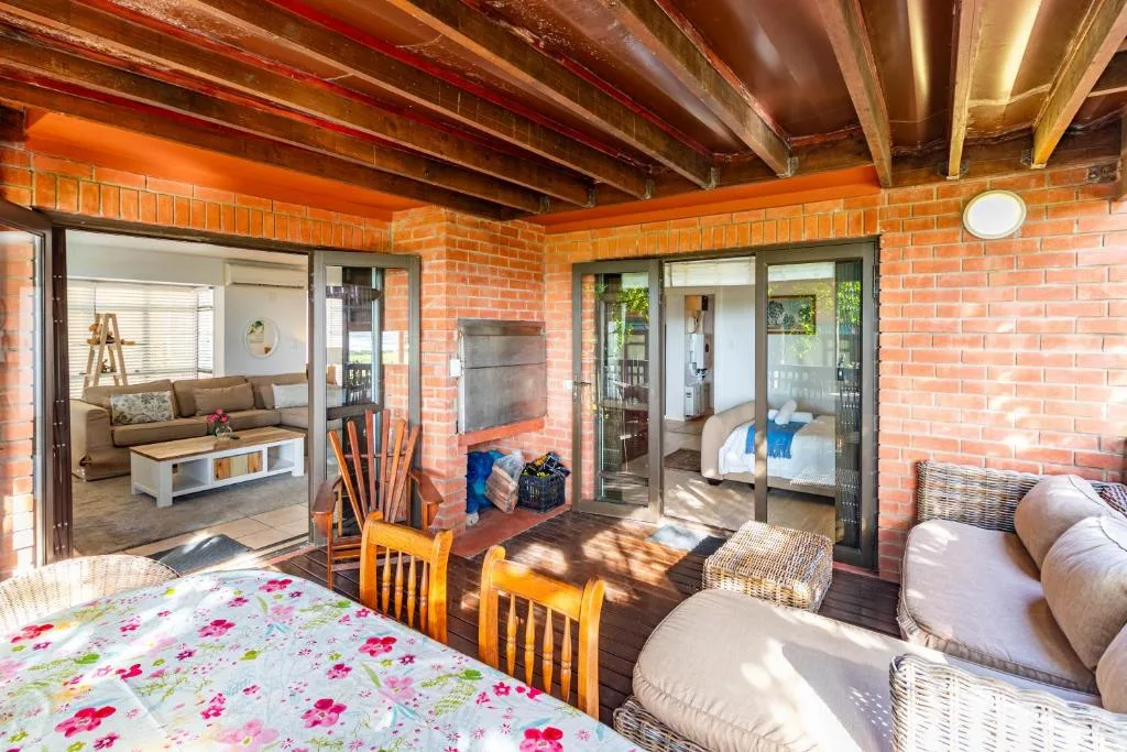 Open-plan interior with exposed beams, brick walls, and multiple room views