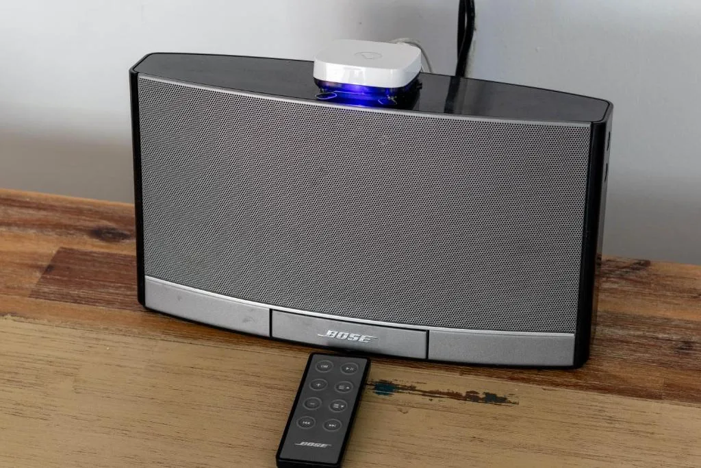 Bose speaker system with remote control on wooden table