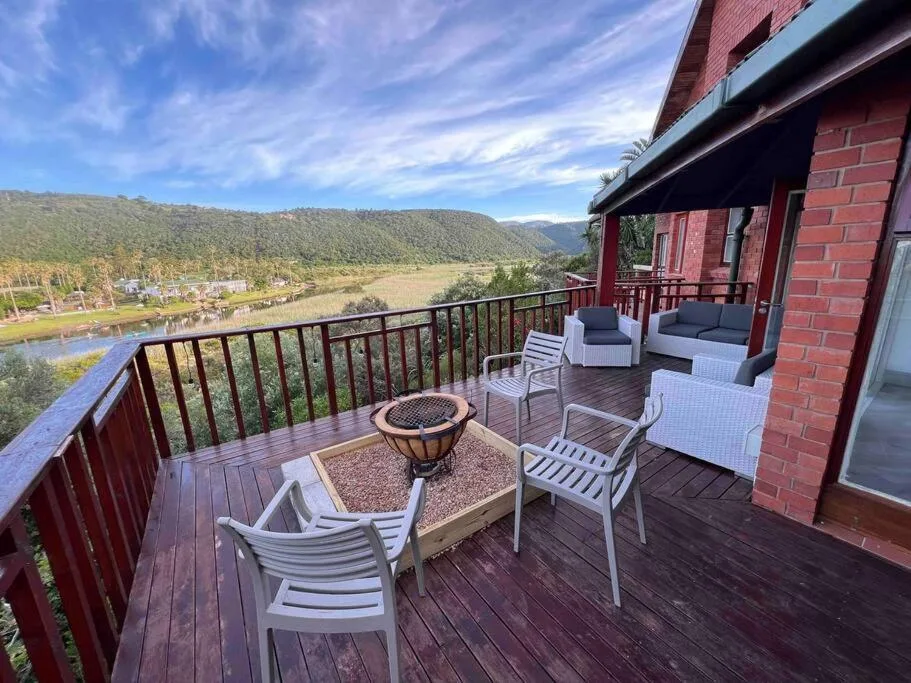 Expansive wooden deck with river valley views, fire pit, and lounge seating