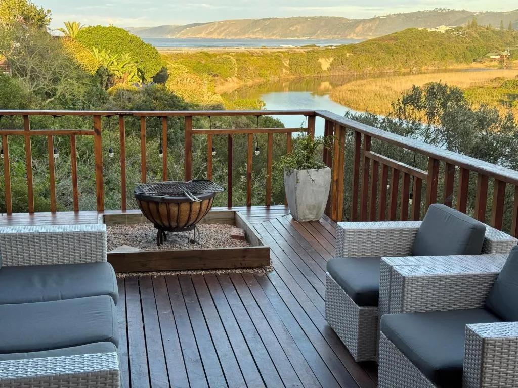 Spacious wooden deck with rattan furniture overlooking lagoon and sea views