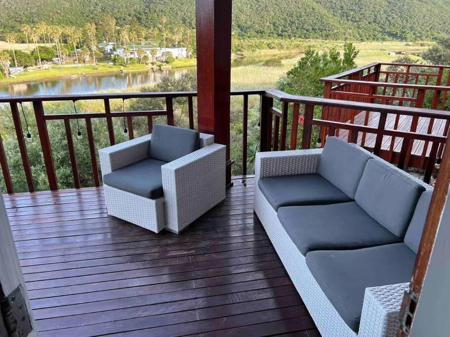 Outdoor deck with rattan furniture overlooking river and mountains