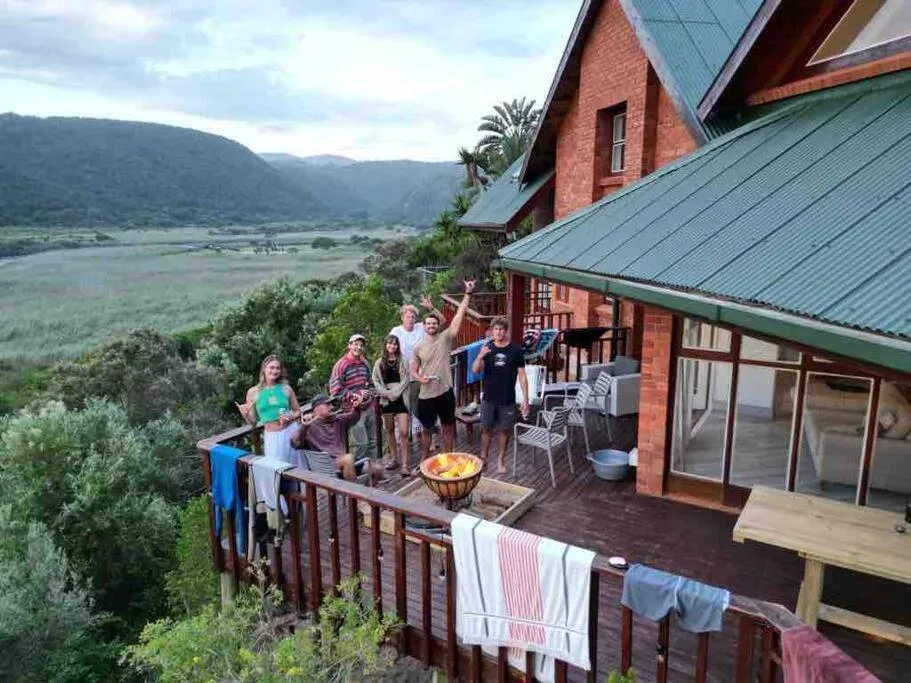Group gathering on wooden deck with scenic valley and river views below