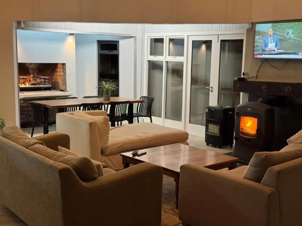 Open-plan lounge with comfortable seating, fireplace, and dining area visible beyond