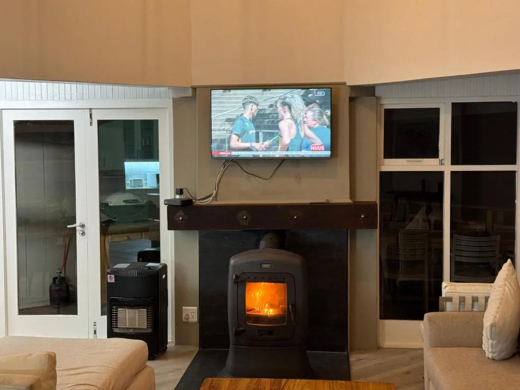 Cozy lounge with fireplace, TV, and comfortable seating area