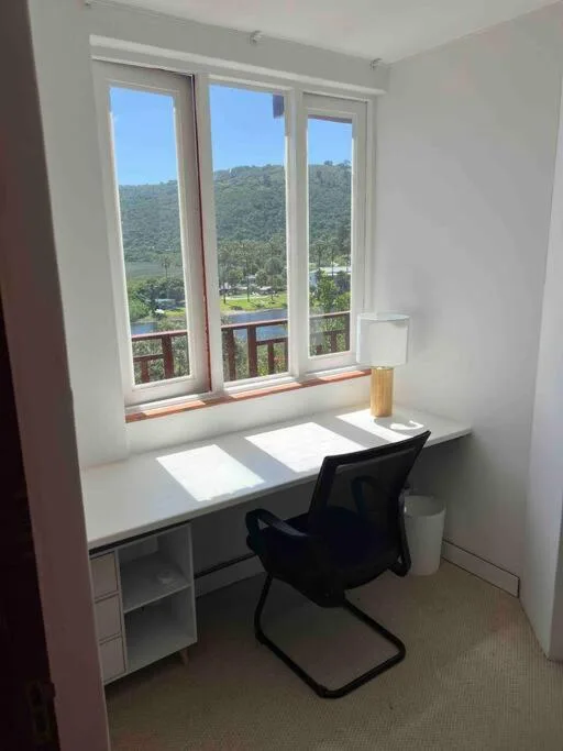 Mountain and river landscape visible through large windows from workspace