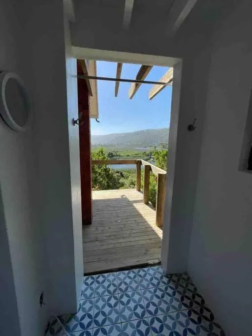Mountain and river valley landscape visible through open deck doorway
