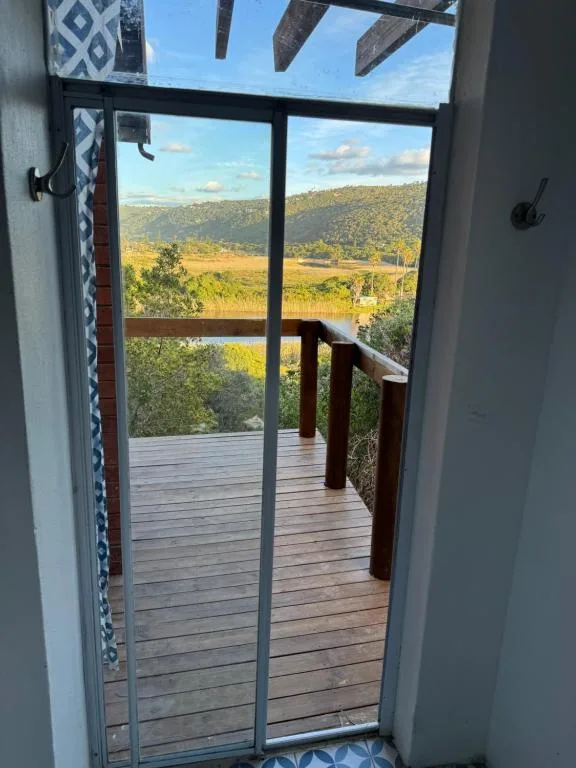 Scenic valley and hillside landscape viewed through open glass doors from deck